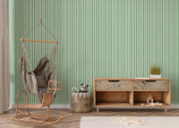 Living corner with hanging chair and green striped wallpaper.