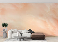 Soft peach watercolor wall mural with flowing abstract paint pattern for living room.