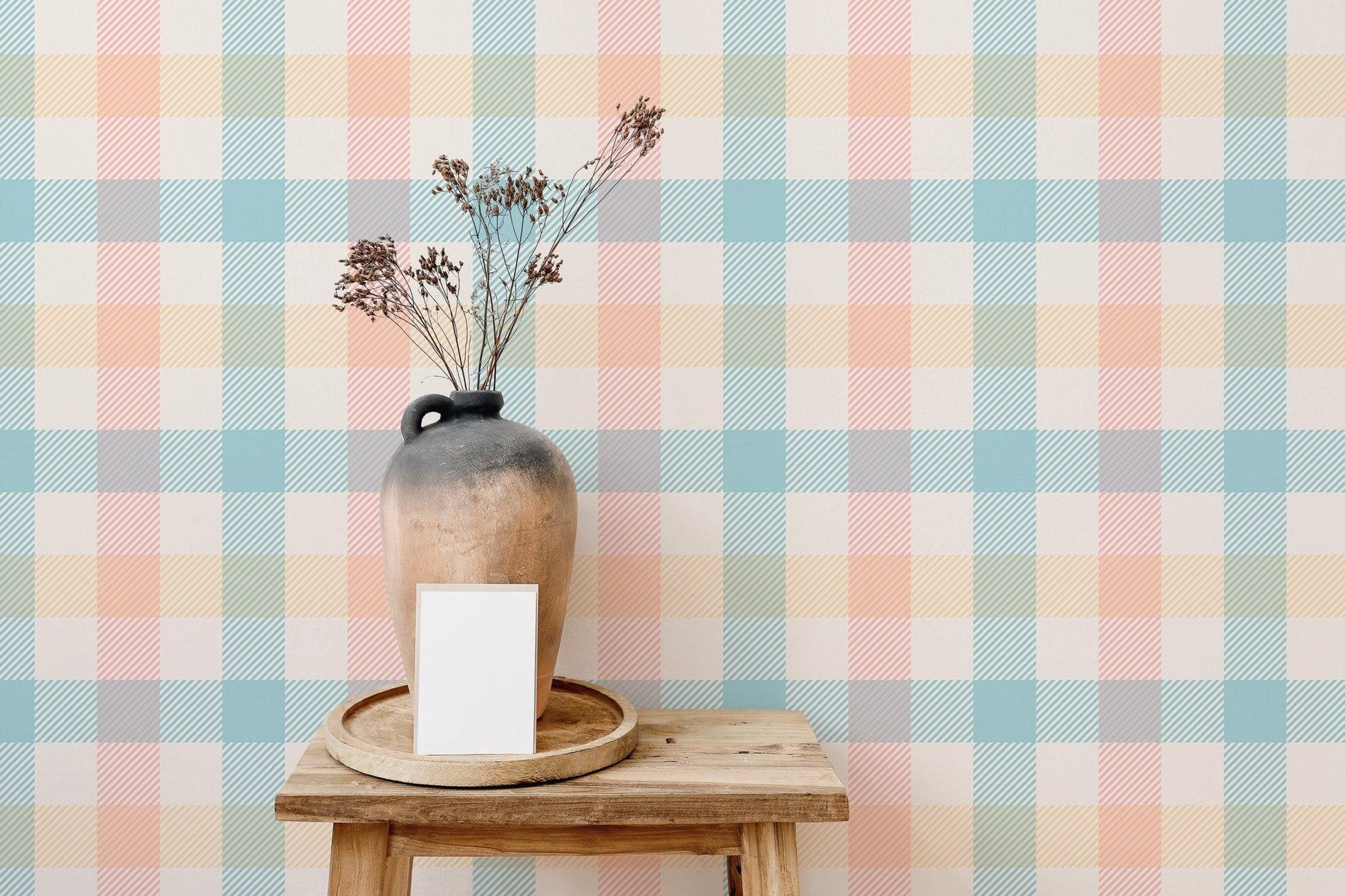 Pastel gingham wallpaper behind a wooden console table with flower vases.