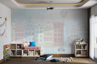 Whimsical mural of antique townhouses in pale pink, cream and green tones.