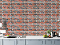 Kitchen counter with a grey and red brick wallpaper backdrop.