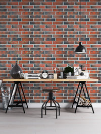 Home office desk setup with a red lining brick wallpaper.