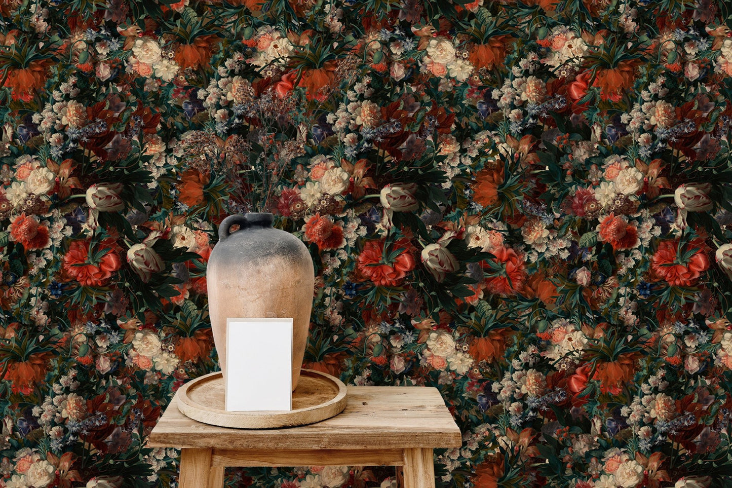Floral wallpaper with red and cream flowers behind a wooden stool and clay vase.