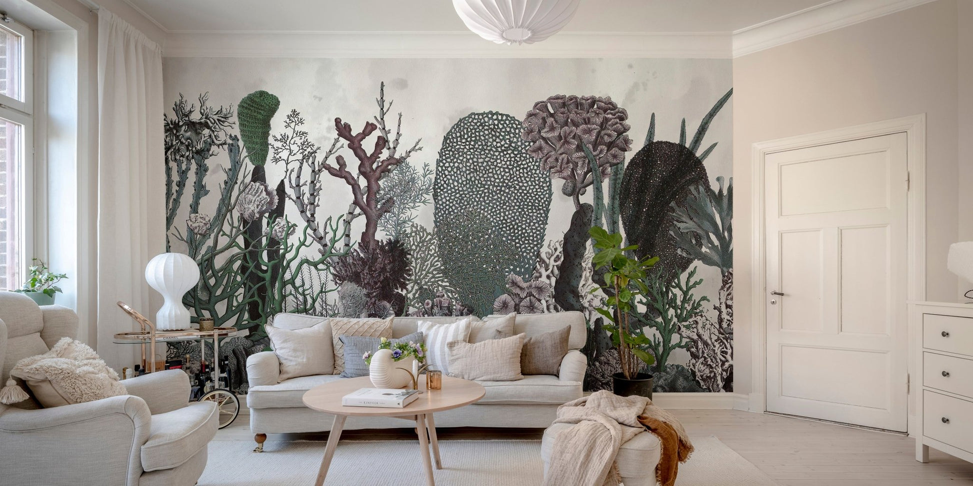 Floral and cactus wall mural in a neutral toned living room with wooden floors.