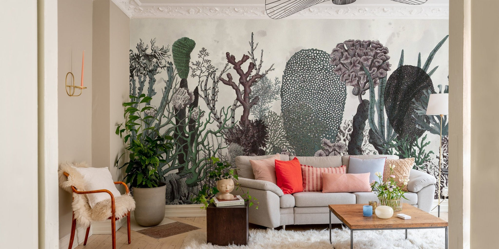 Botanical floral wall mural behind a grey sofa and armchair in a light filled room.