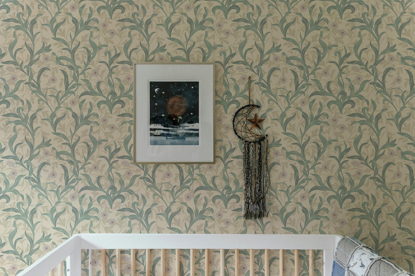 Crib in a room featuring sage green vintage floral print wallpaper.