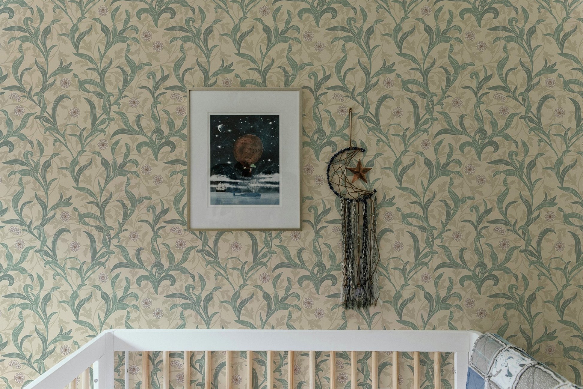 Crib in a room featuring sage green vintage floral print wallpaper.