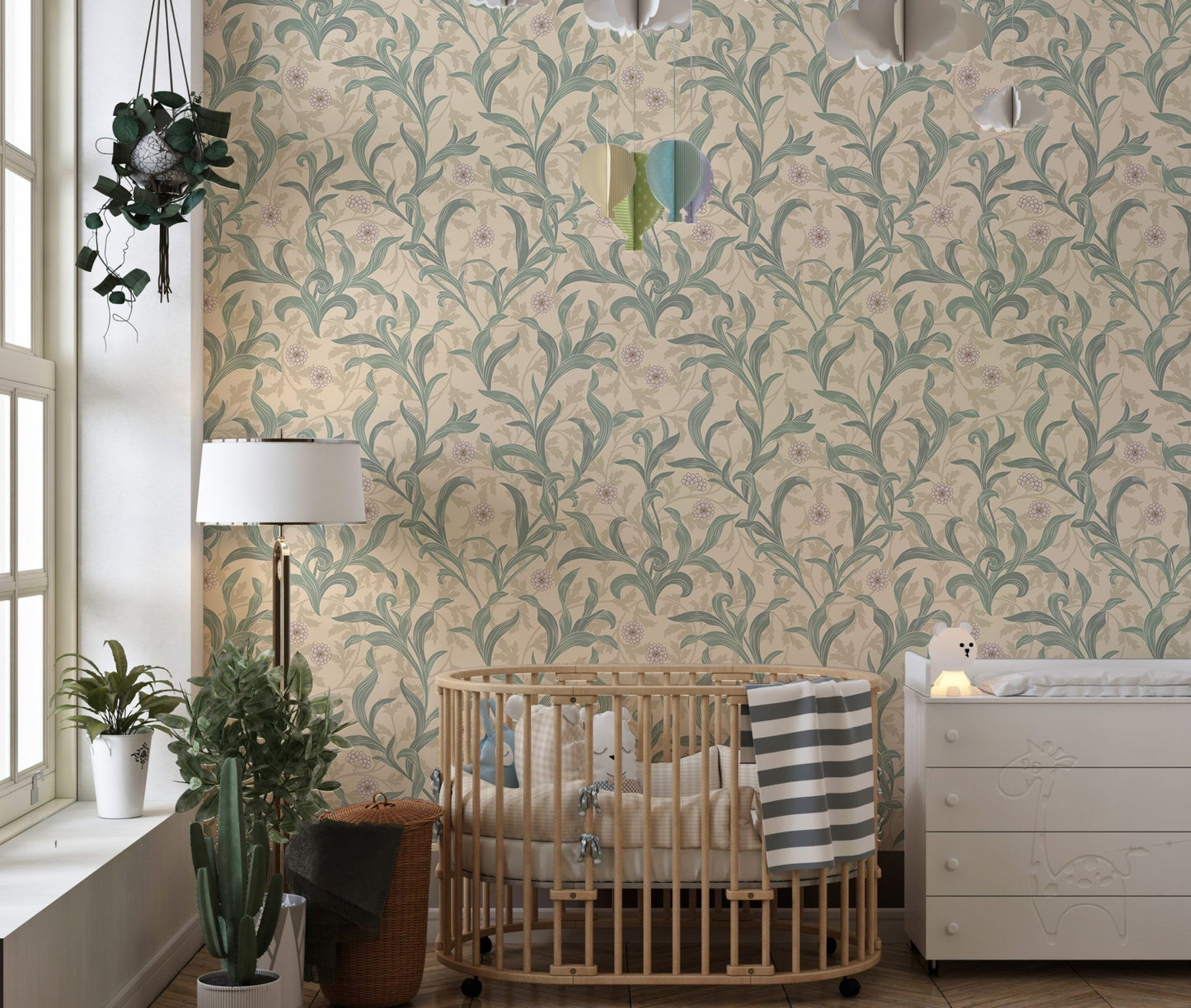 Nursery room wall decorated with sage green vine patterned wallpaper.
