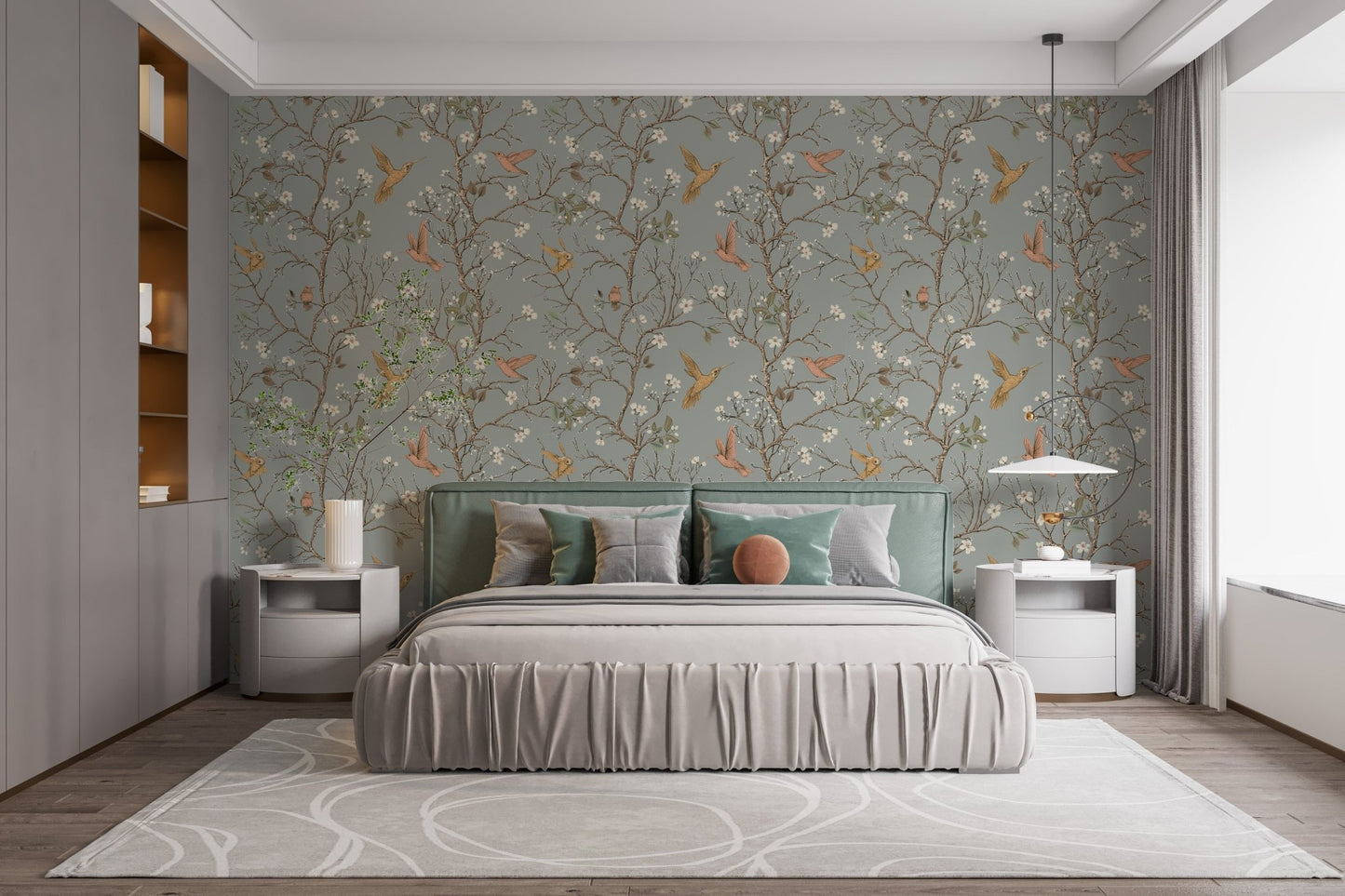 Sage green bird wallpaper behind a large bed with grey linens and white lamps.