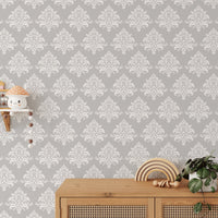 Light grey damask pattern wallpaper on a room feature wall with a large window.