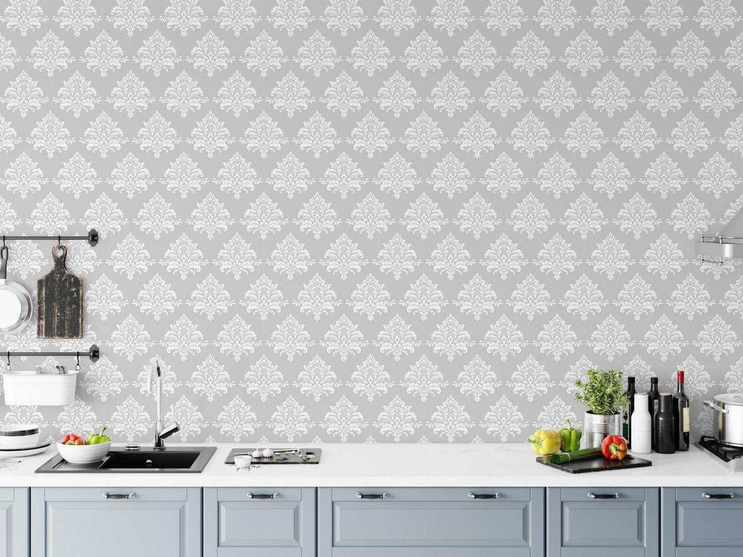 Classic damask wallpaper on a kitchen backsplash wall with blue cabinets.