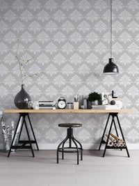 Vintage damask wallpaper in a minimalist workspace with a black stool.