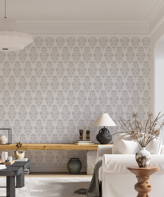 Living area featuring a light grey damask wallpaper behind a wooden console table.