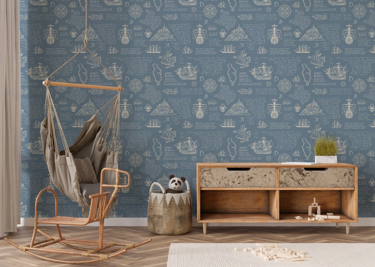 Blue adventure manuscript wall mural in a nursery with a hanging rattan chair