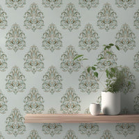 Floating wooden shelf on a green damask wallpaper with small decor items.