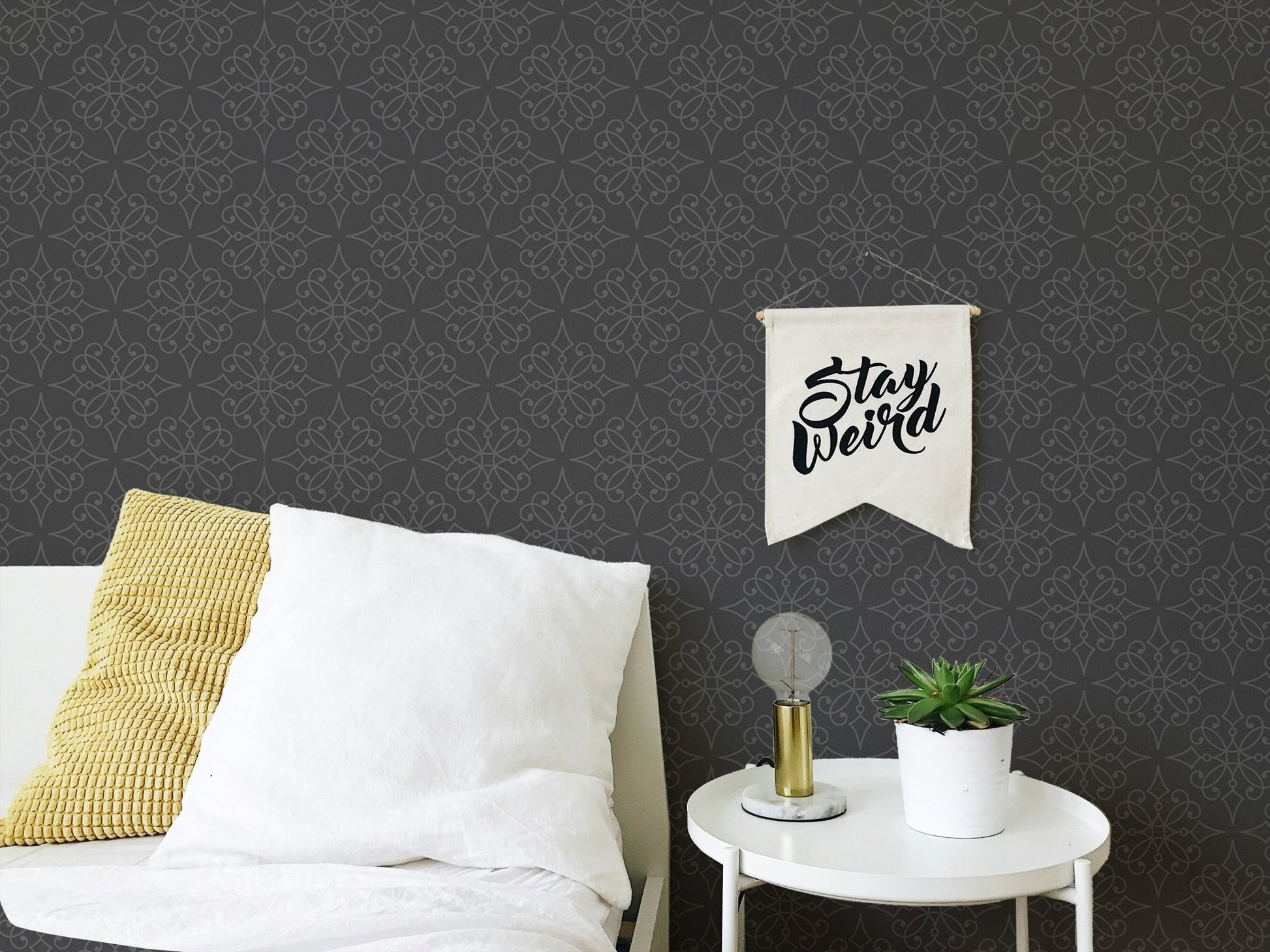 Black ornamental wallpaper behind a white bed with yellow cushions in a bedroom