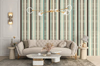Cream and sage green striped wall mural behind a contemporary couch with gold accents.