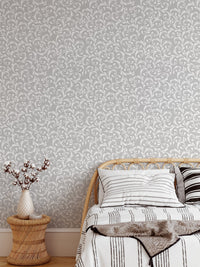 Vintage royal elegant damask pattern wallpaper in a bedroom with a striped bedsheet.