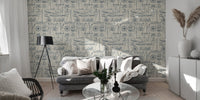 Nautical collage wallpaper behind a grey sofa in a modern living room.