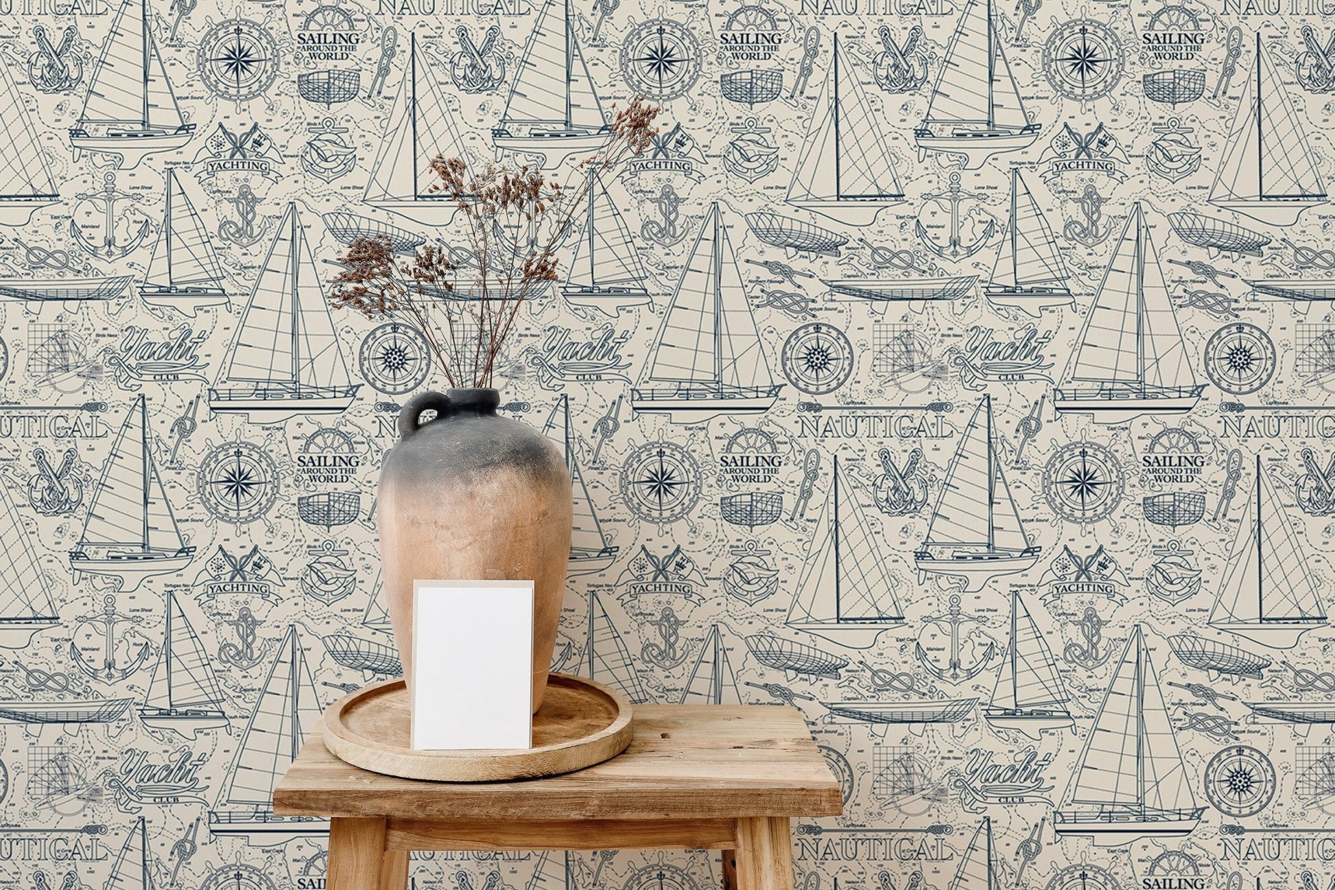 Vintage sailboat wallpaper behind a wooden side table with a ceramic vase.