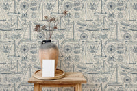 Vintage sailboat wallpaper behind a wooden side table with a ceramic vase.