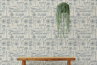 Blue compass and yacht wallpaper behind a wooden bench with hanging plants.