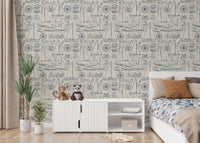 Nautical illustrations wallpaper in a kids bedroom with white furniture.