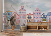 Watercolor seaside houses wall mural in soft blue and pink tones.