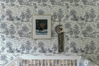 Toile de Jouy style wallpaper in a nursery room with a white crib.