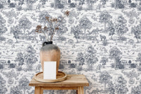 Grey and white tree pattern wallpaper behind a wooden stool and ceramic vase.