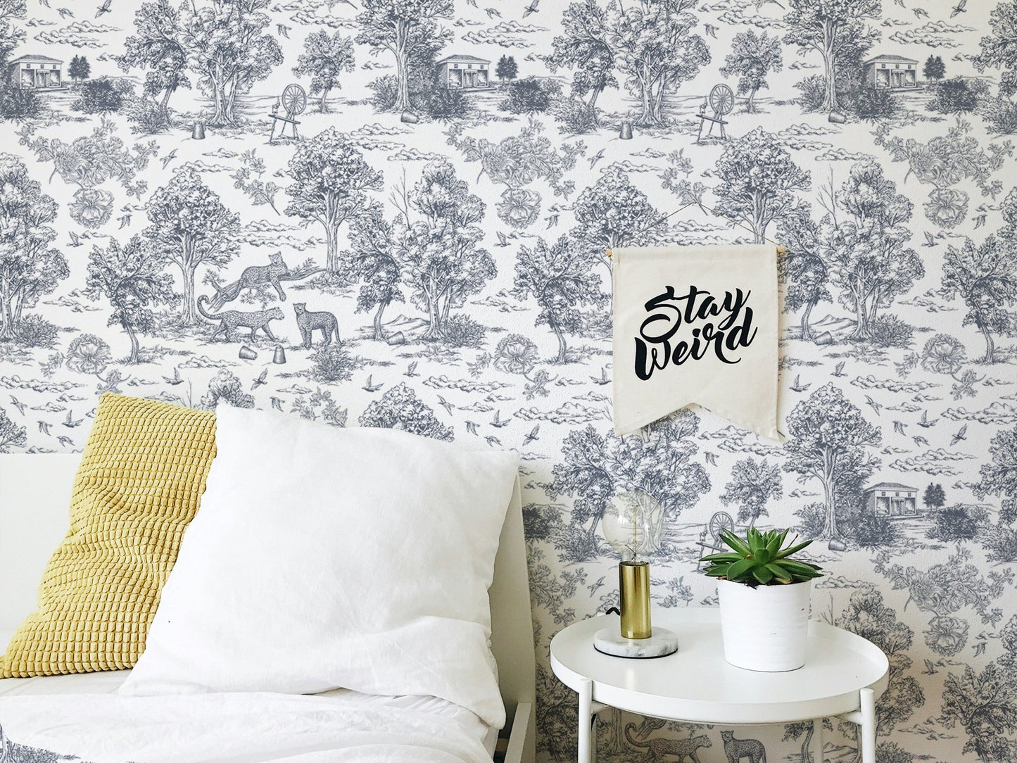 Grey animal print wallpaper in a bedroom with white pillows and yellow cushion.