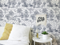 Grey animal print wallpaper in a bedroom with white pillows and yellow cushion.