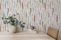 Botanical dry leaves wallpaper used as a backdrop for a minimalist work desk.