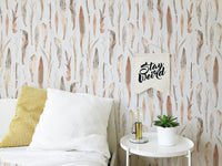 Dry leaves wallpaper in a bedroom with white linens and a yellow cushion.