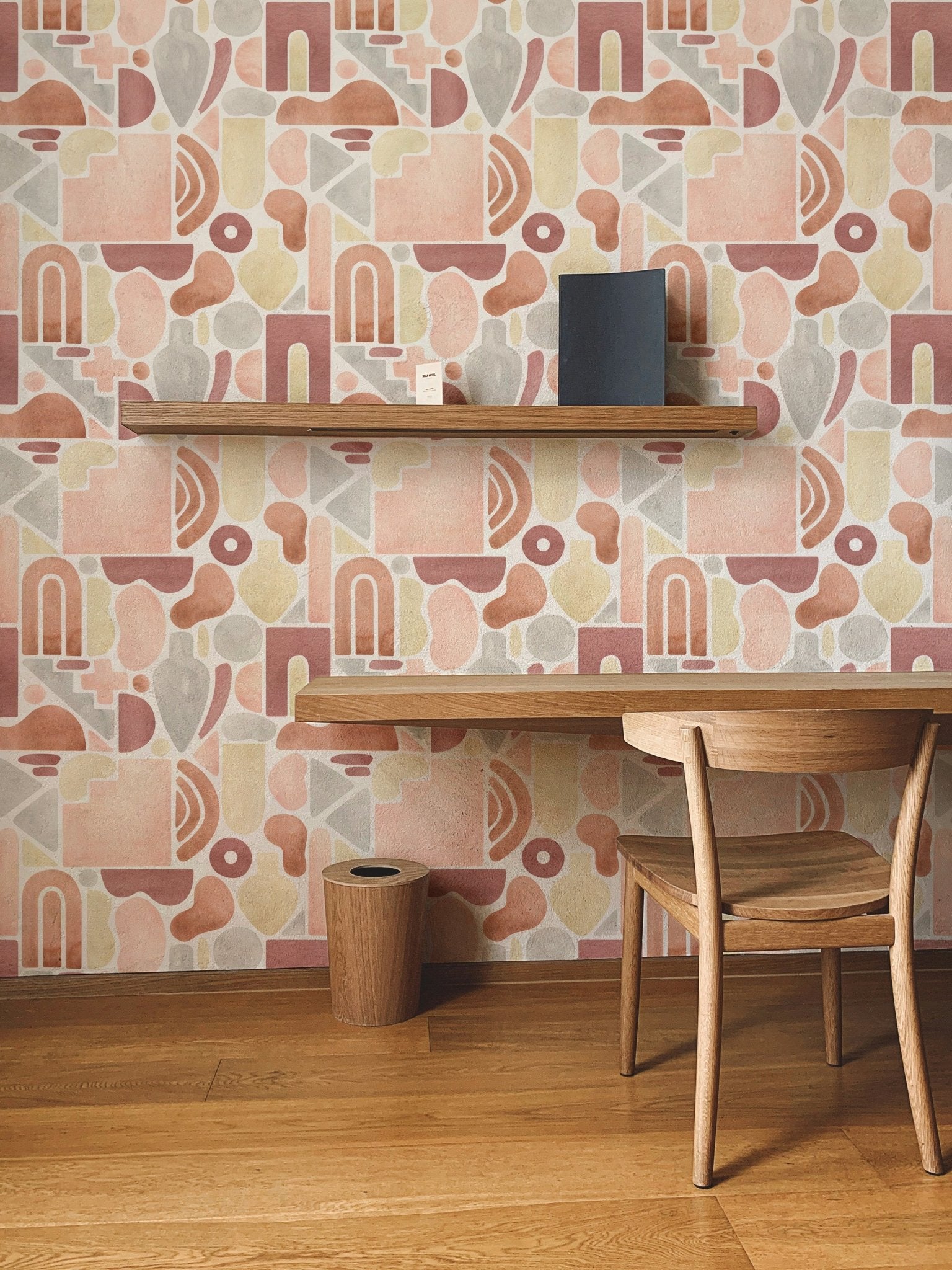 Study corner featuring terracotta boho arch wallpaper and a floating wooden shelf.