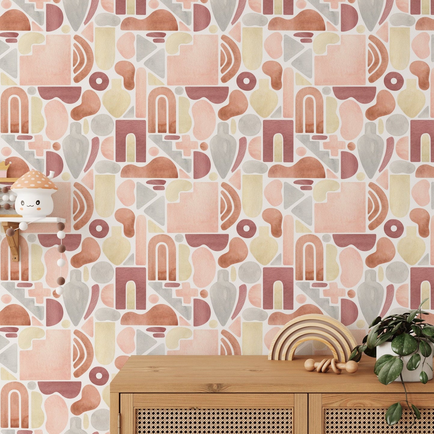 Textured abstract wallpaper with earthy tones behind a light wood sideboard and green plant.