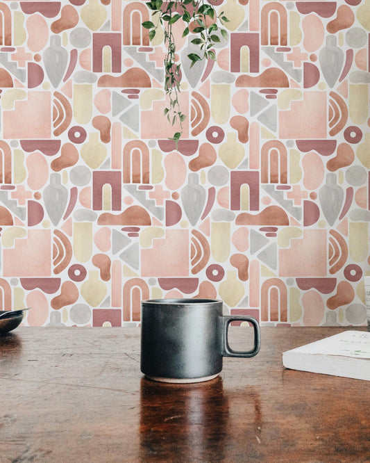 Dining space wallpaper with abstract patterns behind a dark wood table and ceramic mug.