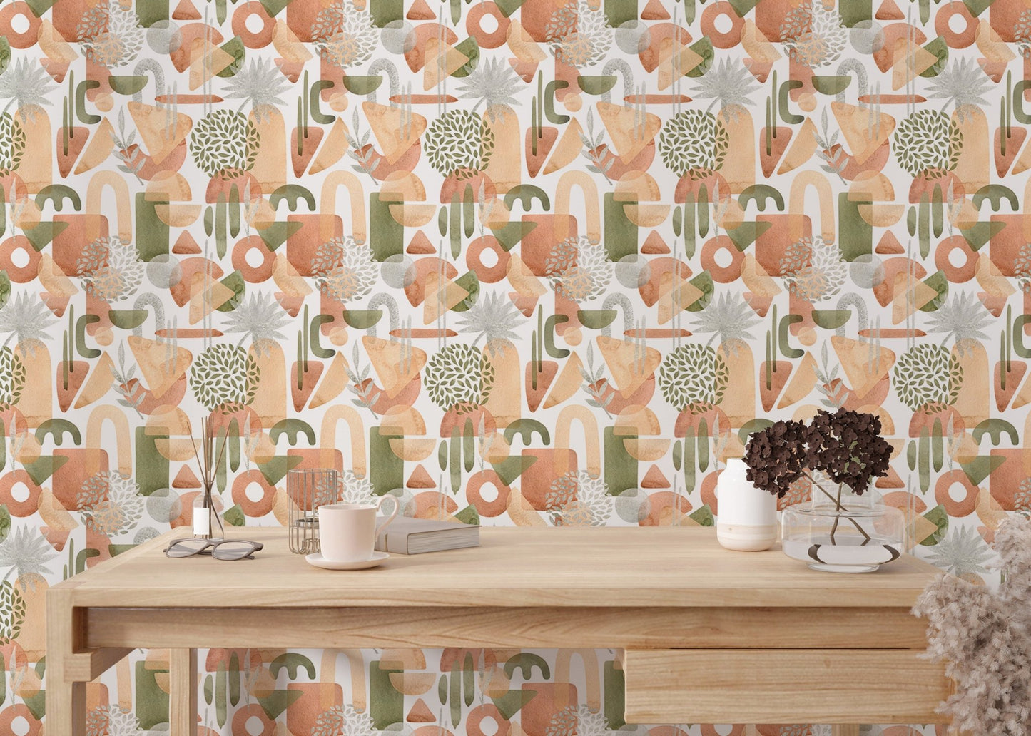 Warm pastel and green watercolor abstract wallpaper behind wooden table.
