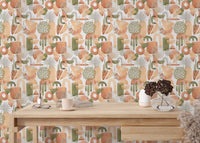 Warm pastel and green watercolor abstract wallpaper behind wooden table.