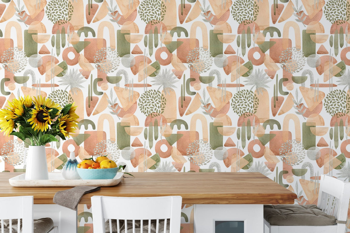 Dining table with chairs and a backdrop of warm pastel green wallpaper.