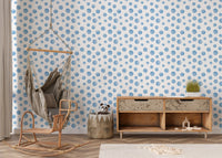 Nursery area with a hanging chair and watercolor blue polka dots wallpaper.