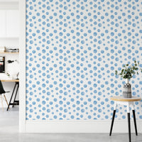 Minimalist hallway with a side table against a blue dotted wallpaper.