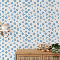 Kids play area featuring wooden furniture and watercolor blue wallpaper.