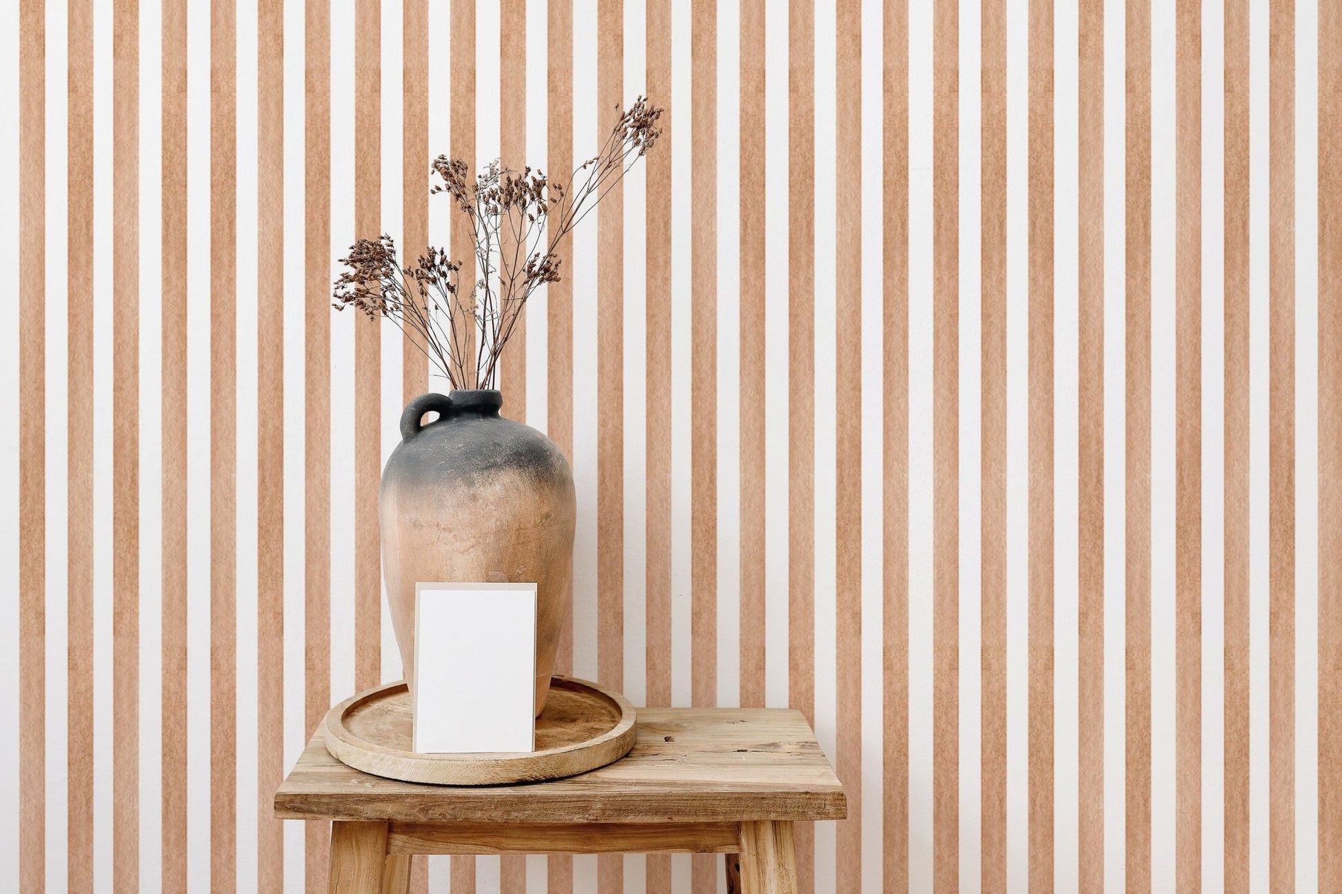 Striped watercolor wallpaper behind wooden table and vase