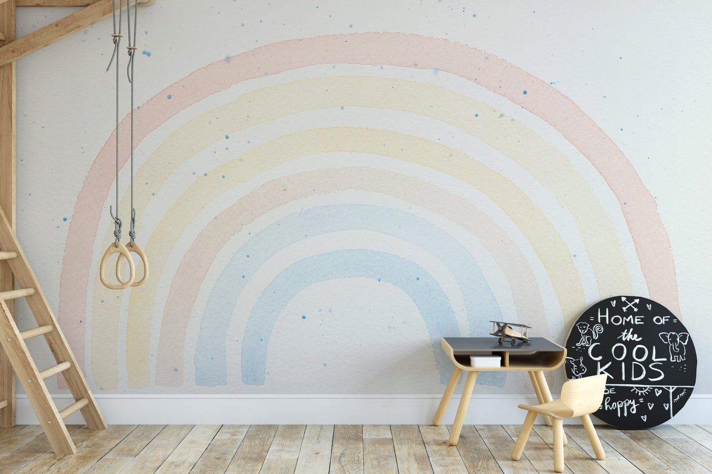 Watercolor rainbow wall mural in study space with small wooden chair and desk