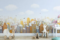 Watercolor City Town Houses Wall mural featuring blue sky and clouds in a nursery.