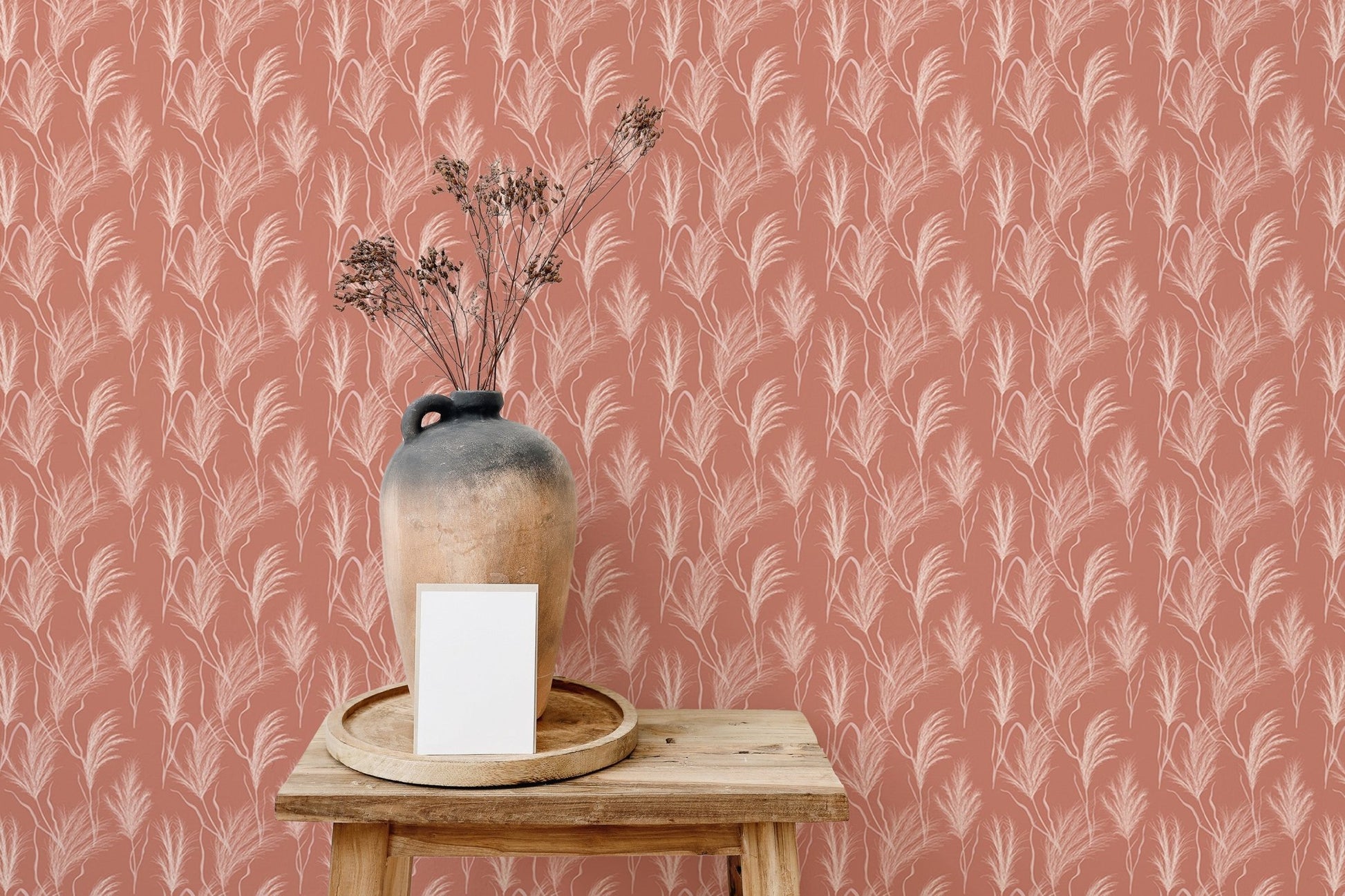 Detail of terracotta boho wallpaper mural behind a wooden stool and vase.