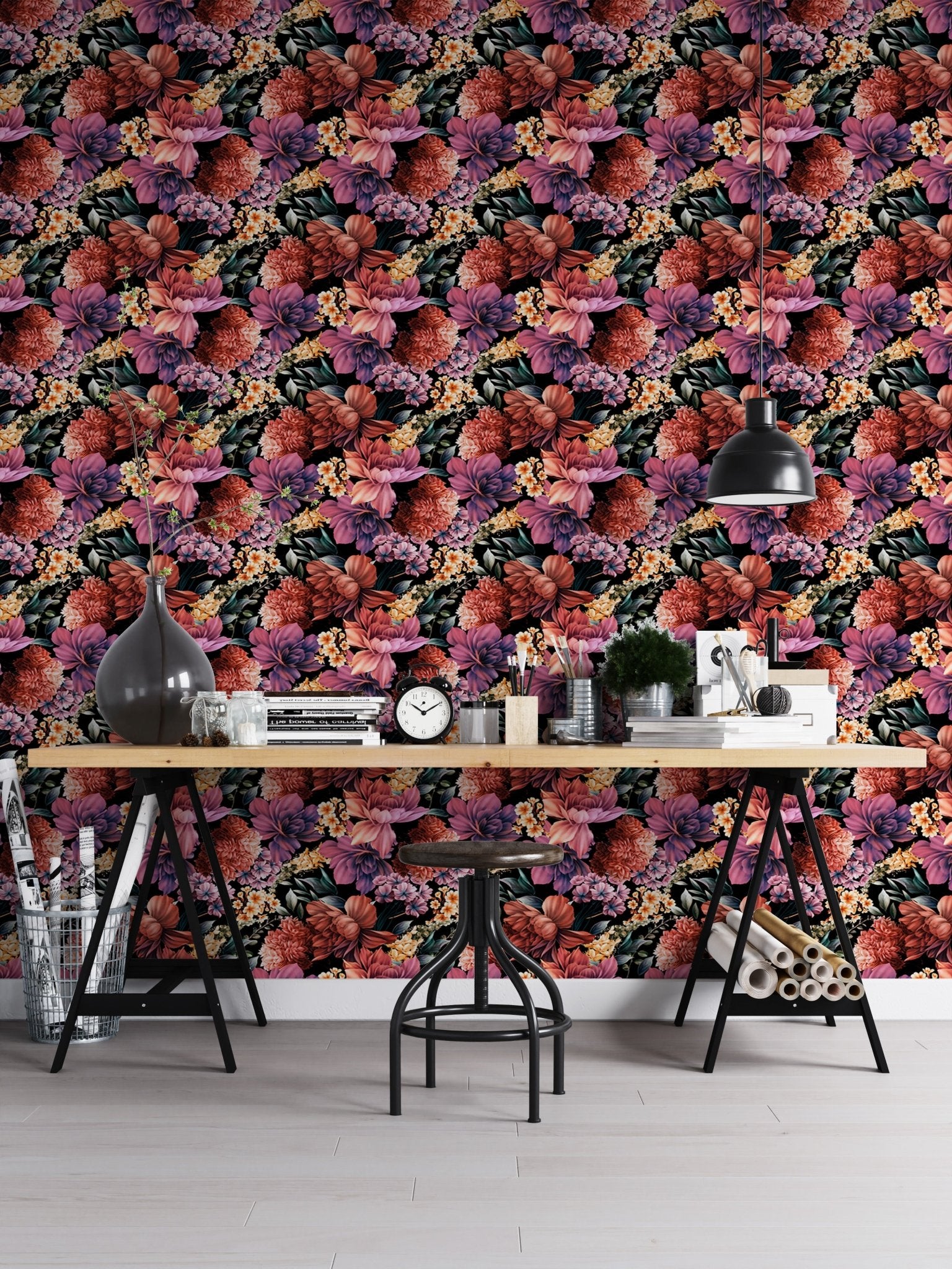 Flower wallpaper on an office wall behind a large desk with stationery and lamp.