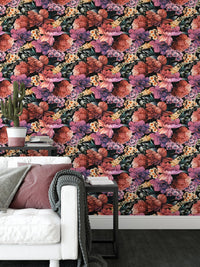 Patterned flower wallpaper behind a white sofa with grey and pink cushions.