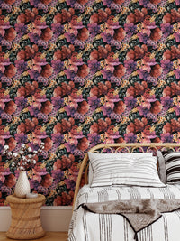 Dark flower wallpaper behind a bed with white pillows and a wooden side table.